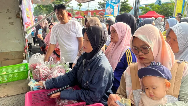 Masyarakat terlihat antri membeli cabai merah murah pada car free day padang, minggu (28/9/25), di depan gerbang kantor gubernur sumatera barat. (mel)