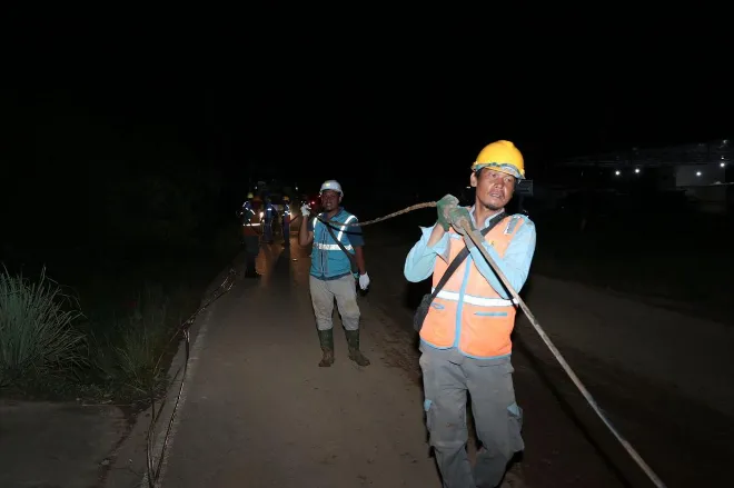 Petugas pln melakukan penarikan jaringan listrik di tengah kegelapan untuk memulihkan pasokan listrik yang terdampak di tapanuli tengah. humas