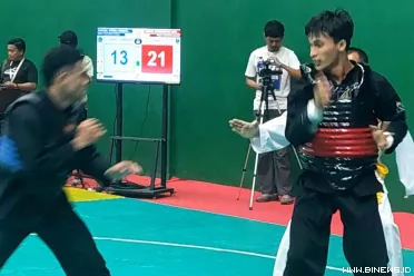 Pesilat Sumbar Fadhil Muhammad Akbar (merah) melangkah ke...